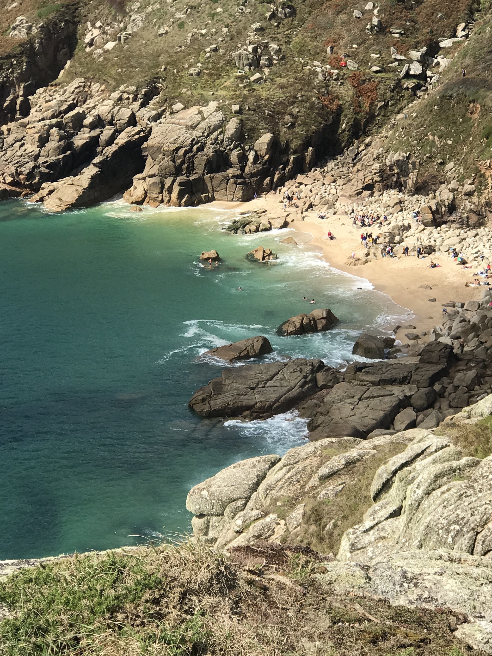 A Cornish cove with turquoise water below granite cliffs